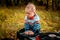 Little chubby kid playing with retro music records outdoors