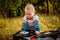 Little chubby kid playing with retro music records outdoors