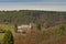 Little church in Ardennes landscape with meadows and pine trees