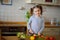 Little cook cooks salad. On a table various vegetables.