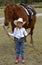 Little Cowgirl Holding Chestnut/Sorrel Horse