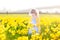 Little curly toddler girl field of yellow daffodil flowers