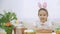 Little cute and adorable girl is smiling sincerely. Girl is pumping over, wearing bunny ears on her head. Concept Easter