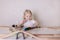 Little cute baby boy 3 years old drinks milk with cookies and plays in the wooden station train set on the table