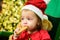 Little cute baby on the christmas tree tasting christmas sweet treats. Close up kids face.