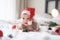 little cute baby girl portreit in red christmas santa hat with lights