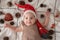 Little cute baby girl portreit in red christmas santa hat with lights top view. Christmas holidays