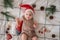 Little cute baby girl portreit in red christmas santa hat with lights top view. Christmas holidays concept