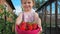 Little cute beautiful girl holds on the outstretched hands a container with strawberries.