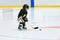 Little cute blond girl plays hockey in full equipment on the stadium