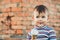 Little cute boy boy boy three years eating ice cream very appetizing on brick wall background