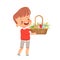 Little cute boy carries a basket with colored eggs, flowers and grass for the Easter holiday. Spring holiday Easter.