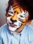 Little cute boy with faceart on birthday party close up, little cute tiger, lifestyle people concept