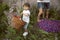 A little cute boy holds a basket in his hands, behind in the background are parents, having a springtime picnic.