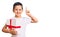 Little cute boy kid holding gift surprised with an idea or question pointing finger with happy face, number one