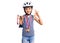 Little cute boy kid wearing bike helmet and winner medals holding winner trophy doing ok sign with fingers, smiling friendly