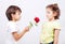 A little cute boy is offering a rose to little gir