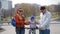 Little cute boy with parents learning to ride a bike