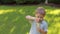 A little cute boy playing with soap bubbles in a green Park at sunset.