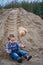 Little cute boy riding a roller coaster of sand on the bottom. Memories childhood and carefree