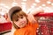 Little cute boy with shopping cart full of fresh organic vegetables and fruits standing in grocery department of food