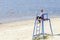 Little cute boy is sitting at the watchtower on the beach with