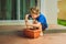 Little cute boy sows seeds in a flower pot in the garden