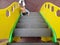 A little cute Caucasian baby climbs the yellow stairs on a children`s playground. on the floor on a rubberized safe