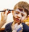 Little cute child making facepaint on birthday party, zombie Apocalypse facepainting, halloween preparing concept