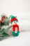Little cute crocheted snowman in a red hat and scarf on a white background