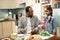 Little cute daughter coming to kitchen seeing father making sandwiches