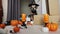 little cute dog in a halloween costume and hat among halloween decorations
