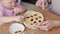 Little cute funny girl helping mother prepare pie cake in kitchen, baking homemade cookie together, happy family time.