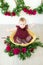 Little cute girl 1 year old in a dress of Marsala color with a wicker basket with peonies. Spring and flowers.