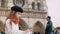 Little cute girl in beret and red scarf sitting near the Notre Dame and drawing the sketch in Paris, France.