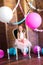 Little cute girl with blond hair in a pink dress and a princess crown with large bright balloons and garlands. Children`s holiday.