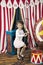 Little cute girl climbs rope ladder on background of circus scenery. World circus day. New year concept