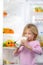 Little cute girl drinking milk near open fridge