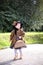 Little cute girl in hat and cloak with handbag in autmn pa