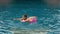 The little cute girl have fun in the pool. The child enjoy summer vacation in a swimming pool jumping, spinning, splash