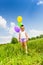 Little cute girl holding three flying balloons