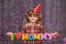 Little cute girl holds a garland with text `I love mommy` of colorful paper alphabet