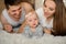 Little cute girl lying on the bed among her parents