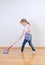 Little cute girl mopping floor.