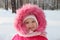 Little cute girl in pink stands in forest and smiles