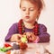 Little cute girl playing indoors with colored toys developmen