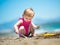 Little cute girl playing in the sand