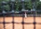 Little cute girl playing tennis outside at the tennis court