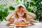 Little cute girl playing with wooden toy pizza. Preschool child having fun with children activity like, play with food