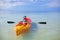 Little cute girl rowing a boat in blue clear sea